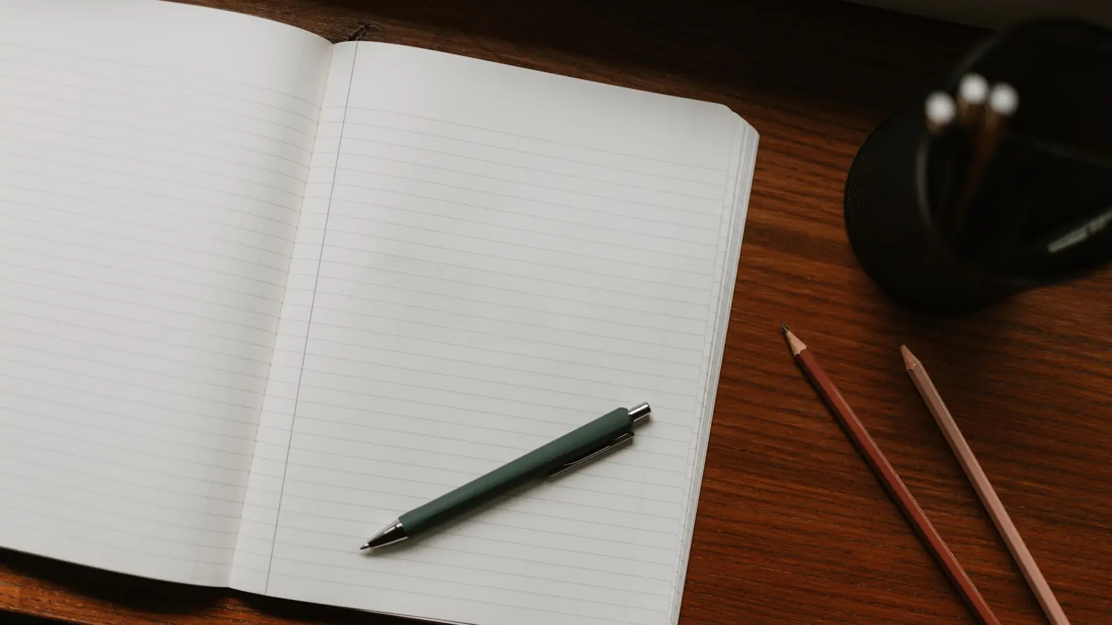 Carnet ouvert avec un stylo posé sur un bureau en bois — préparation du choix d'un abonnement IPTV